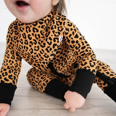 Close up image of a child wearing a Classic Leopard Bandana Bib and matching Zippy