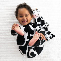 Child wearing a Moo Crew printed pj set paired with a Charlie the Cow lovey