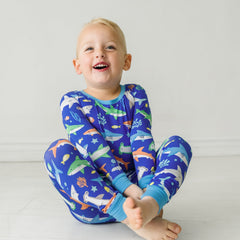 Child sitting on the ground wearing a Rad Reef two-piece pajama set