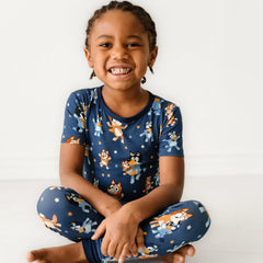 Child sitting on the ground wearing a Bluey Dance Mode two-piece short sleeve pajama set