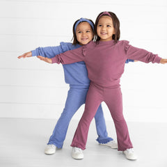 Two girls holding hands wearing play leggings in Watercolor Checks and Positive Vibes