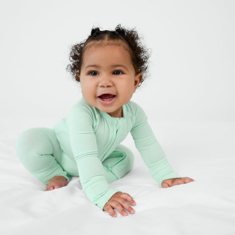 Crawling child wearing the Pastel Green zippy