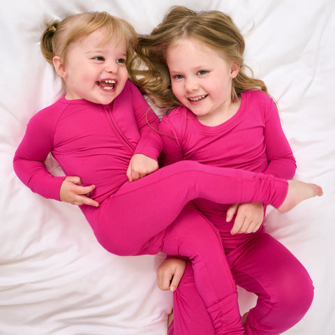 Two children wearing matching Mighty Magenta pjs