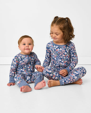 Two children wearing matching Petite Petals pajamas