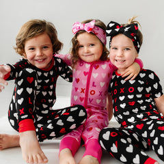 three children wearing coordinating XOXO pjs 