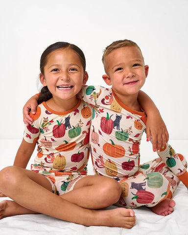 Two children wearing matching Pumpkin Pals fall pajamas