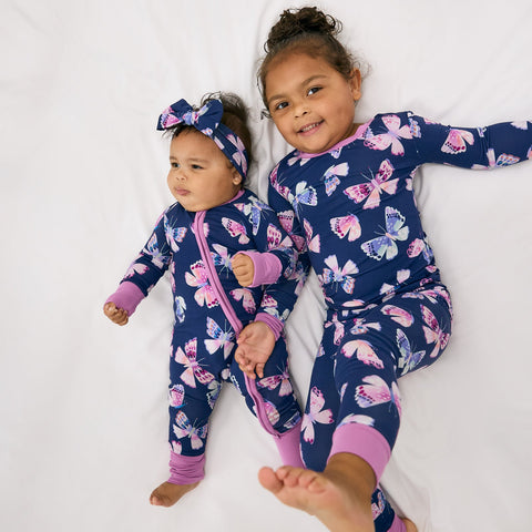 Two children wearing matching butterfly print bamboo pajamas