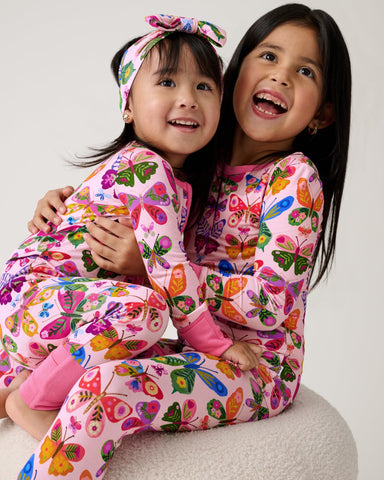 Two sisters wearing matching Flutter Garden pajamas