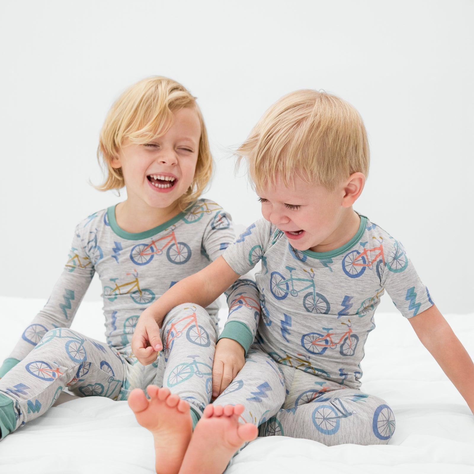 Two children wearing matching Let's Ride bamboo pajamas