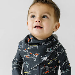 Child in Take Flight printed zippy pajamas with matching bandana bib