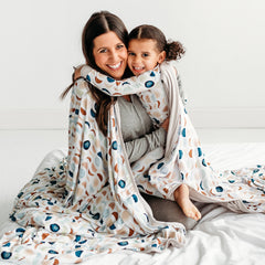 Man and woman wrapped up wearing a Classic Blue Chevron printed oversize cloud blanket