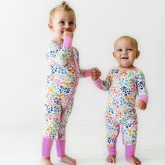 Two children wearing Rainbow Leopard printed pajamas