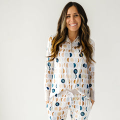Cropped image of a woman wearing Luna Neutral printed pajama top and pajama pants. This print features phases of the moon in the sweetest shades of creams, tans, and navy watercolor in an all over repeat pattern.