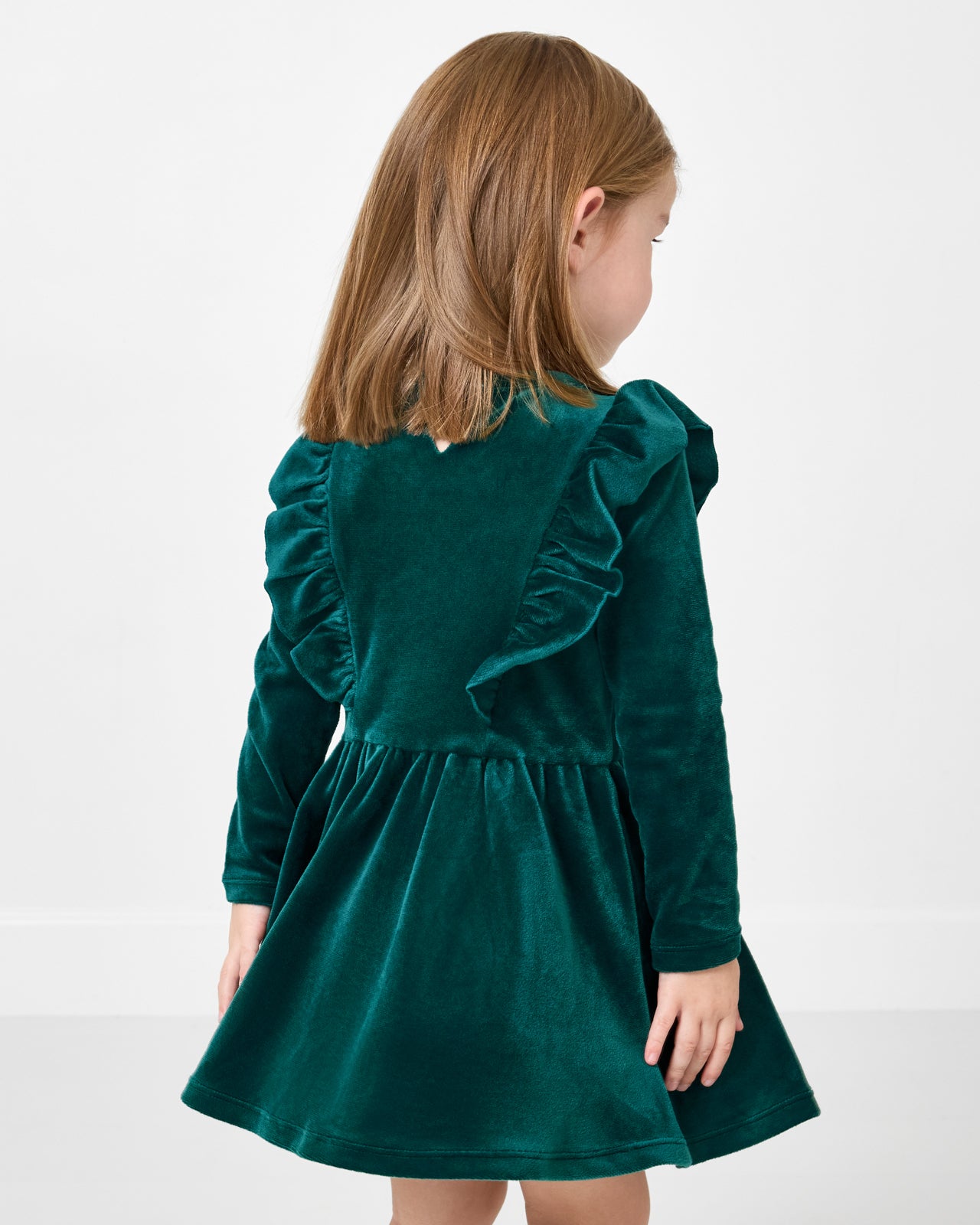Back view of girl wearing the Emerald Velvet Easy Fit Flutter Dress