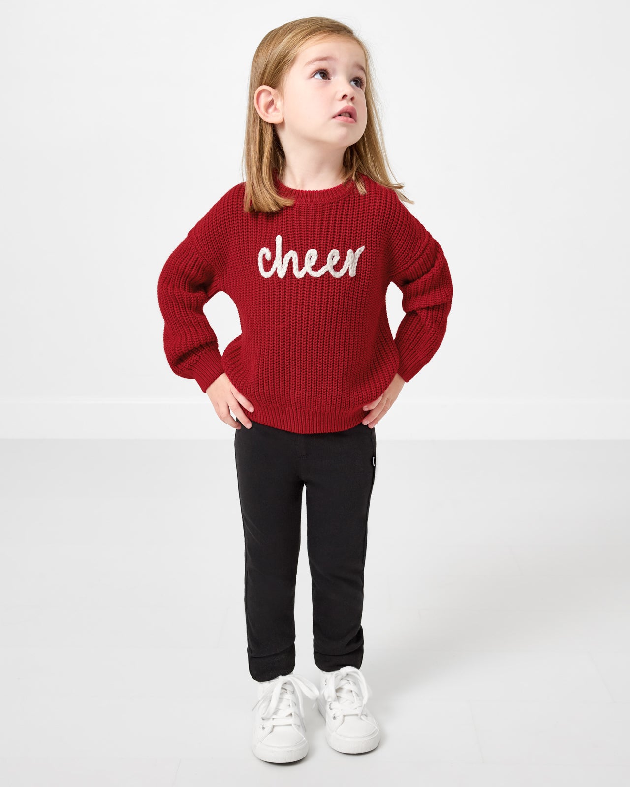 Standing girl wearing the Cheer Drop Shoulder Sweater with black pants