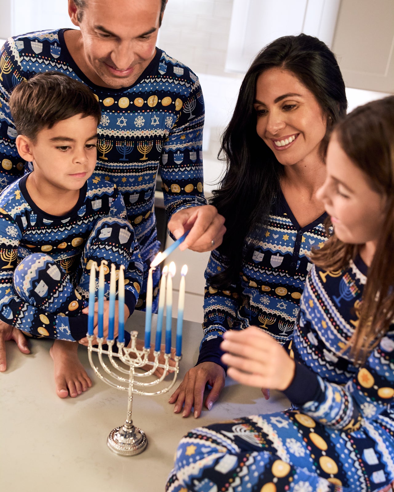 Family of four wearing matching Hanukkah Fair Isle bamboo pajamas