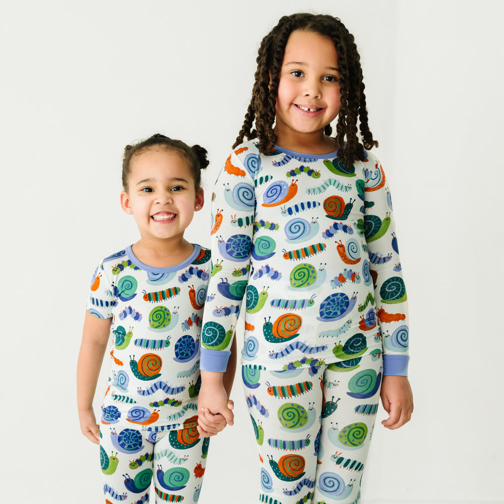 Two children holding hands wearing matching Inchin' Along pajamas