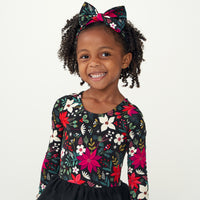 child wearing a Merry Berry tiered tutu dress paired with a Berry Merry luxe bow headband