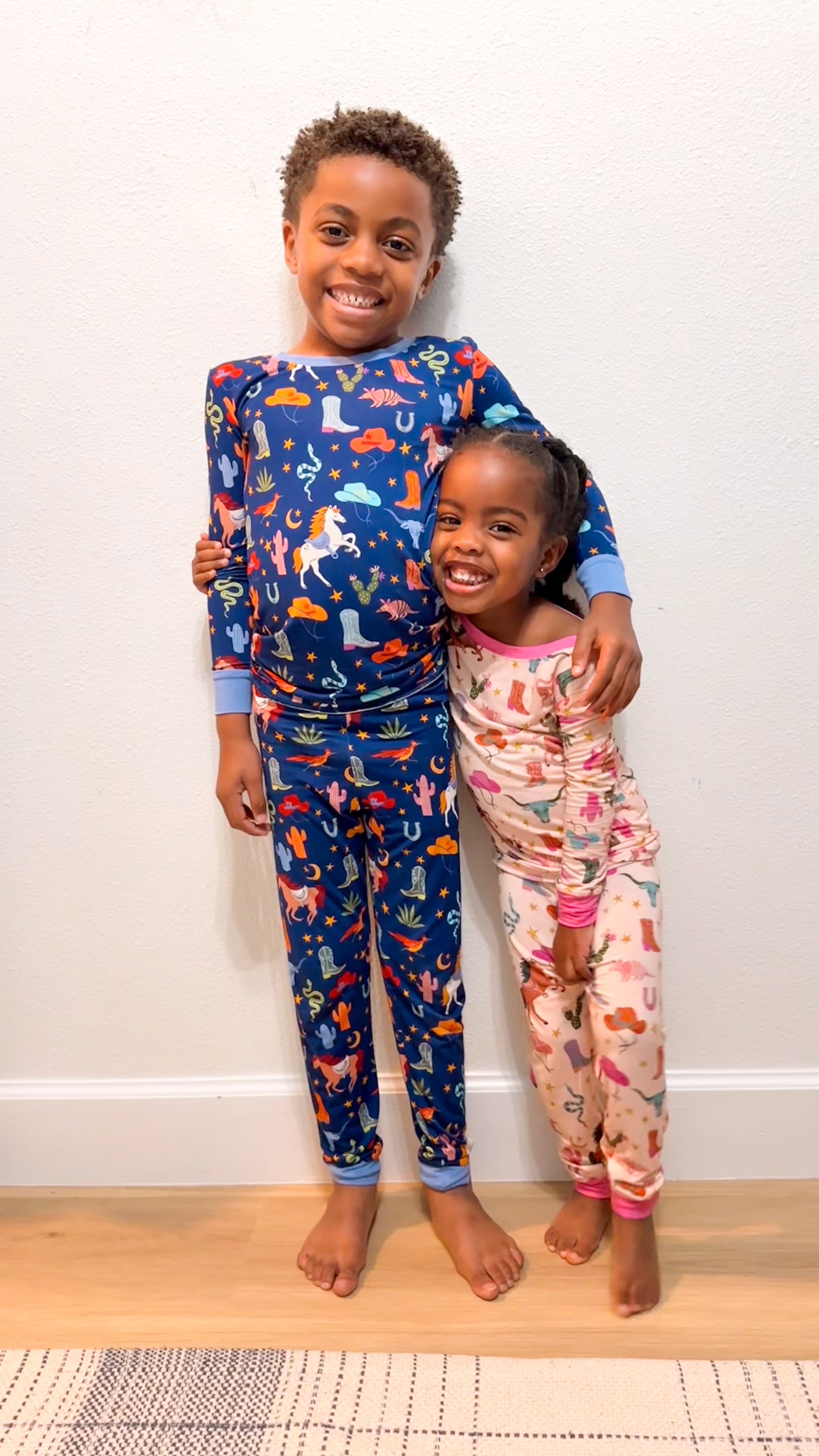 Two siblings wearing matching Rancher Roundup Two-Piece Pajama Sets