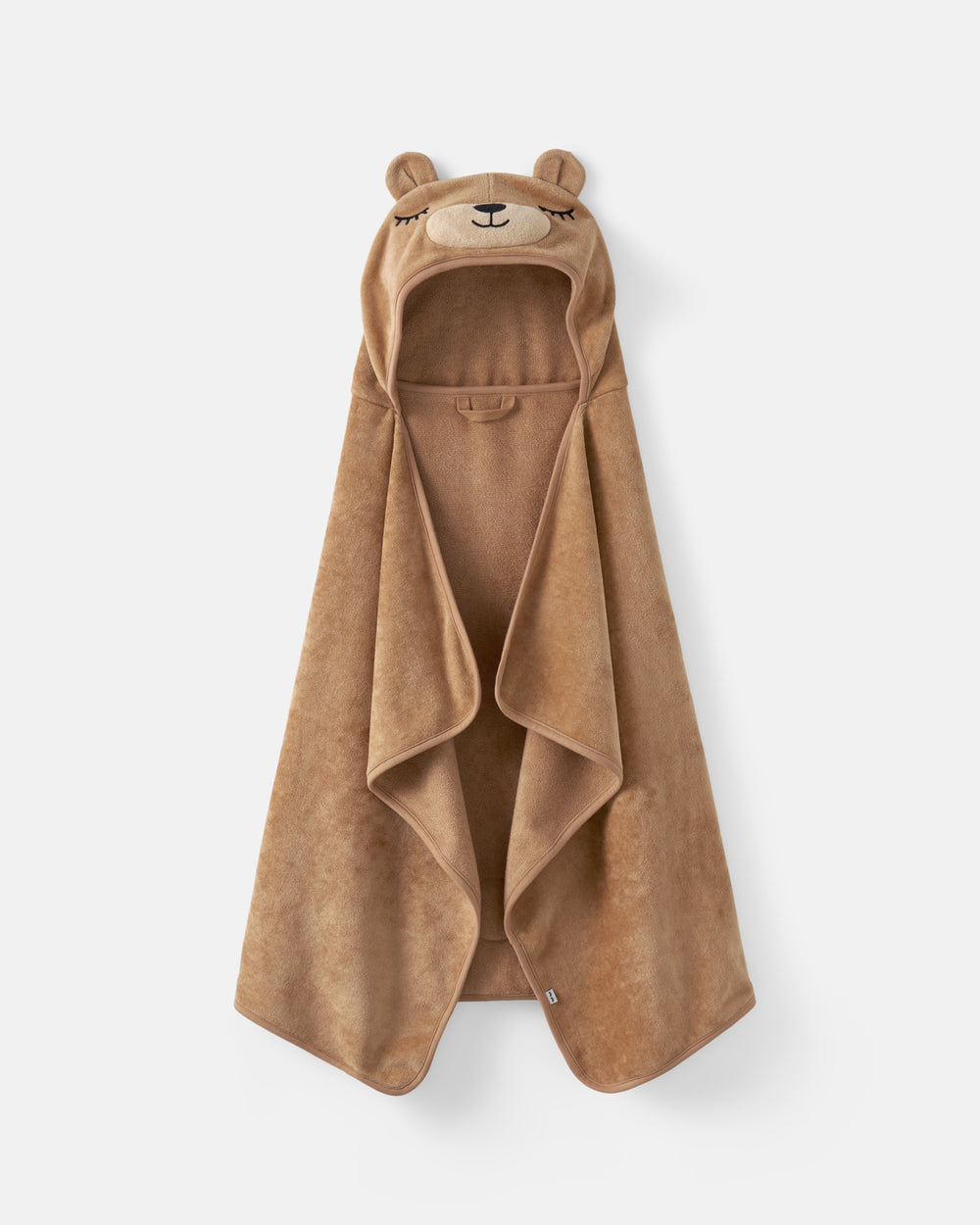 A plush hooded towel in a warm tan-brown color, featuring a bear face design on the hood with small ears and embroidered eyes and nose, shown against a light gray background.