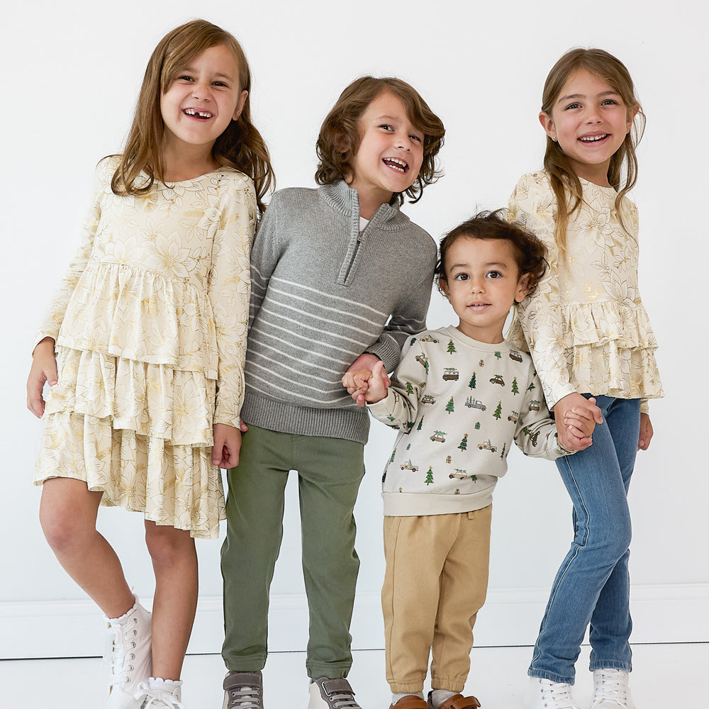 Four children holding hands wearing coordinating Holiday Play styles