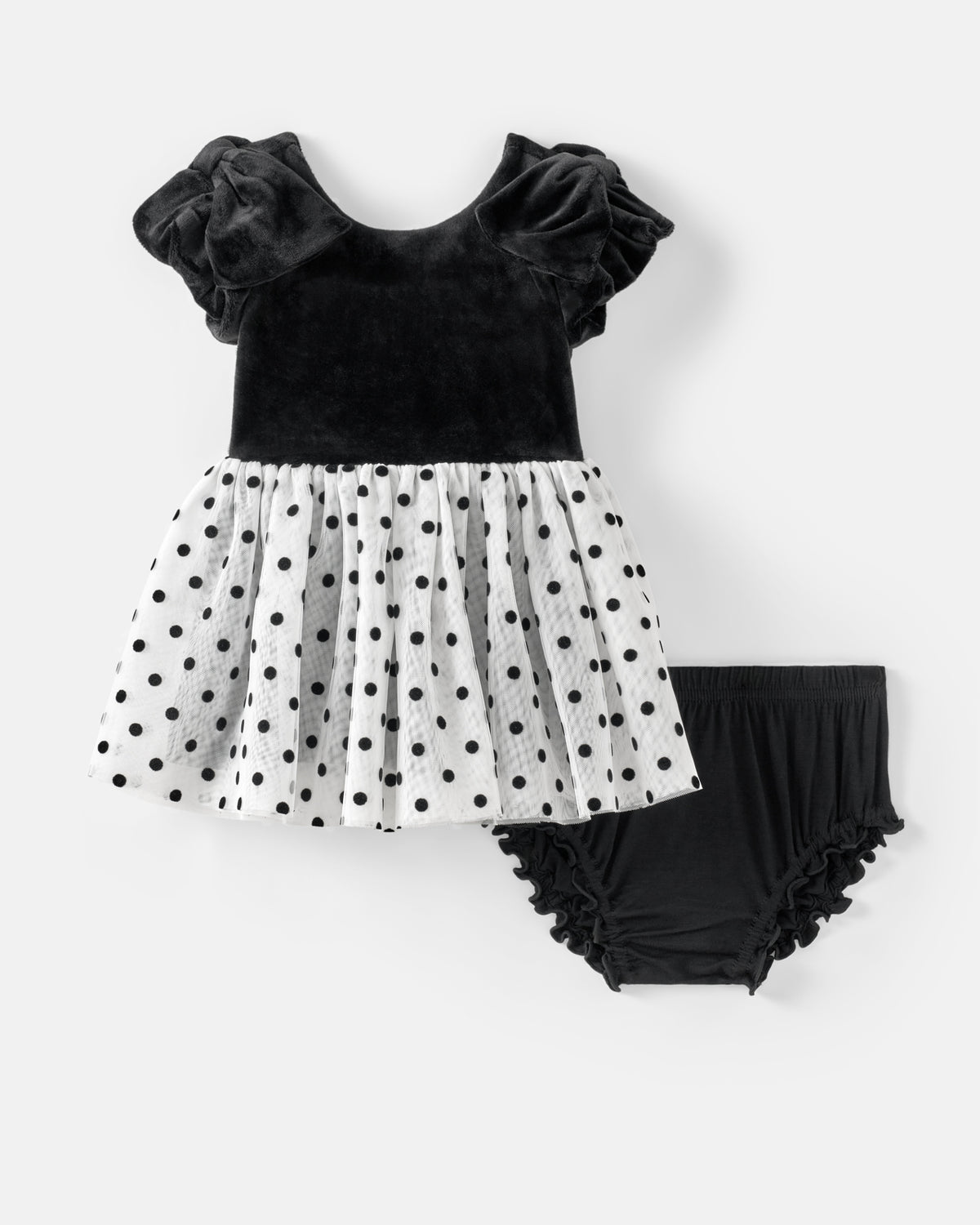 A toddler girl's two-piece outfit set featuring a black velvet top with ruffled flutter sleeves and a white polka-dot tulle skirt, paired with black ruffled bloomers, shown on a light gray background.