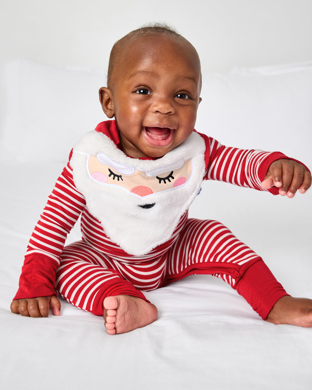 Baby wearing the Santa Bandana Bib with a candy cane stripe zippy