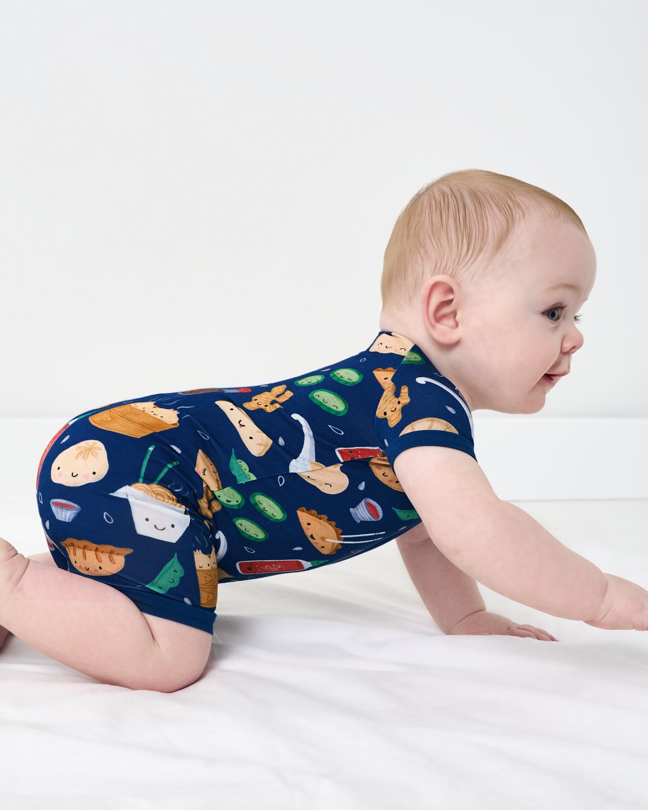 Crawling baby wearing the Bao Buddies Shorty Zippy