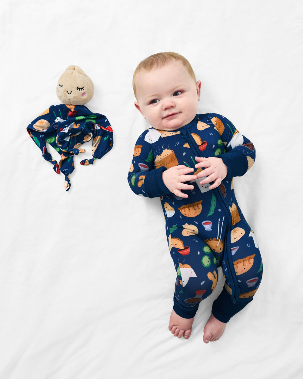 Aerial view of baby laying with the Suki the Dumpling Sleepyhead Lovey