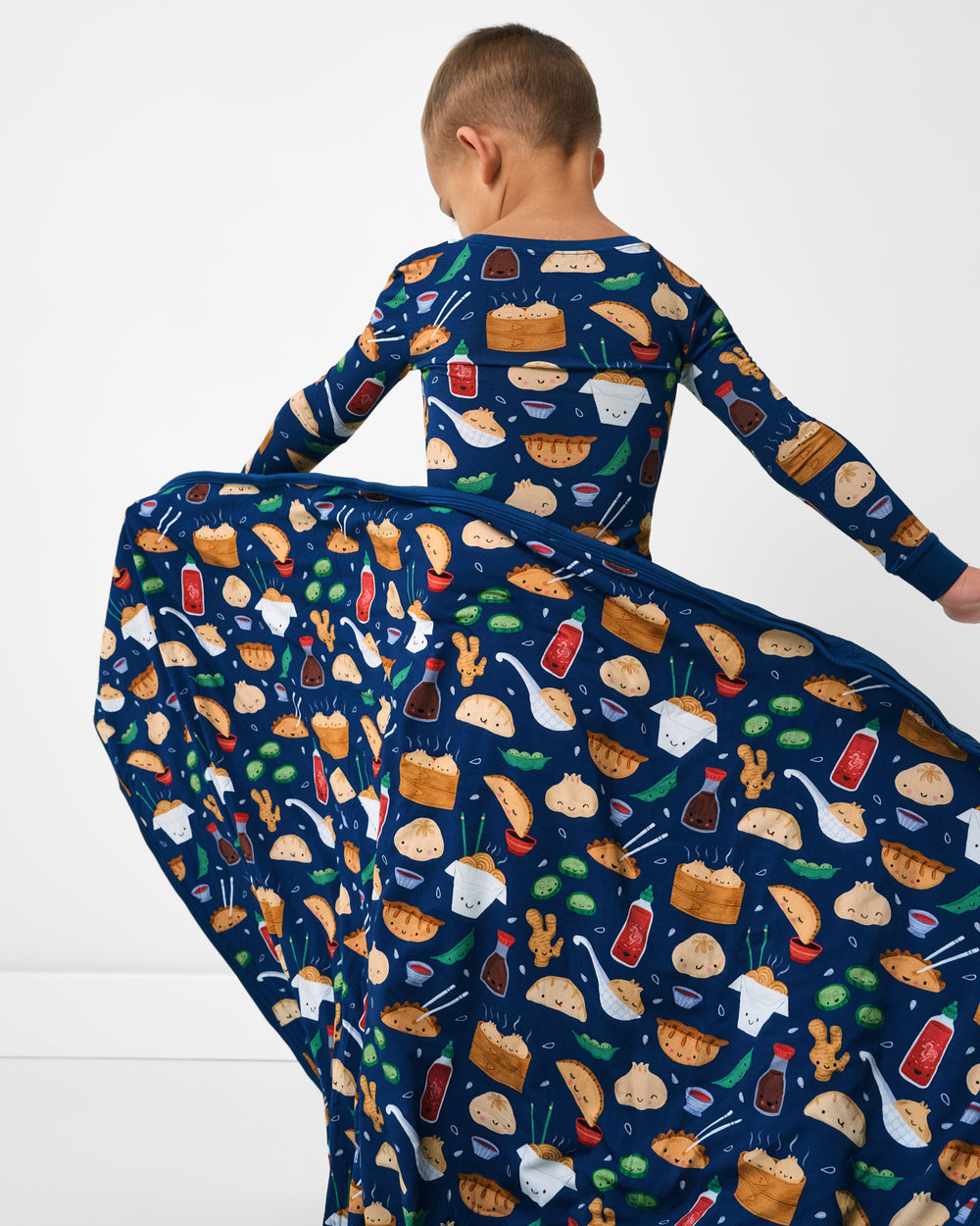 Back view of boy holding the Bao Buddies Large Cloud Blanket®