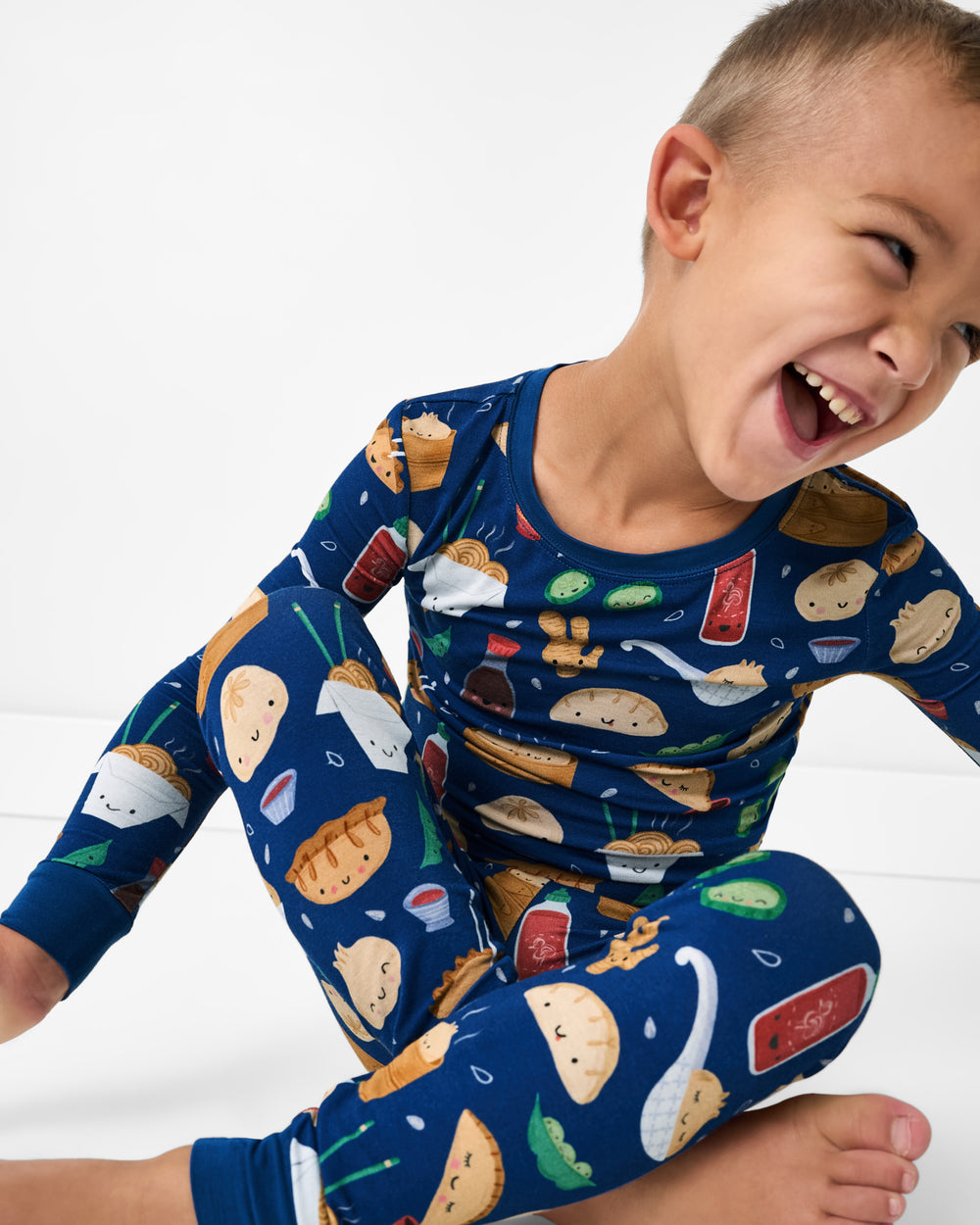Close up of sitting boy wearing the Bao Buddies Two-Piece Pajama Set