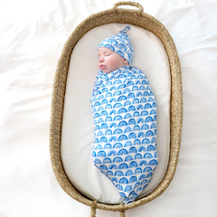 baby in basket sleeping wearing blue rainbows swaddle set with hat