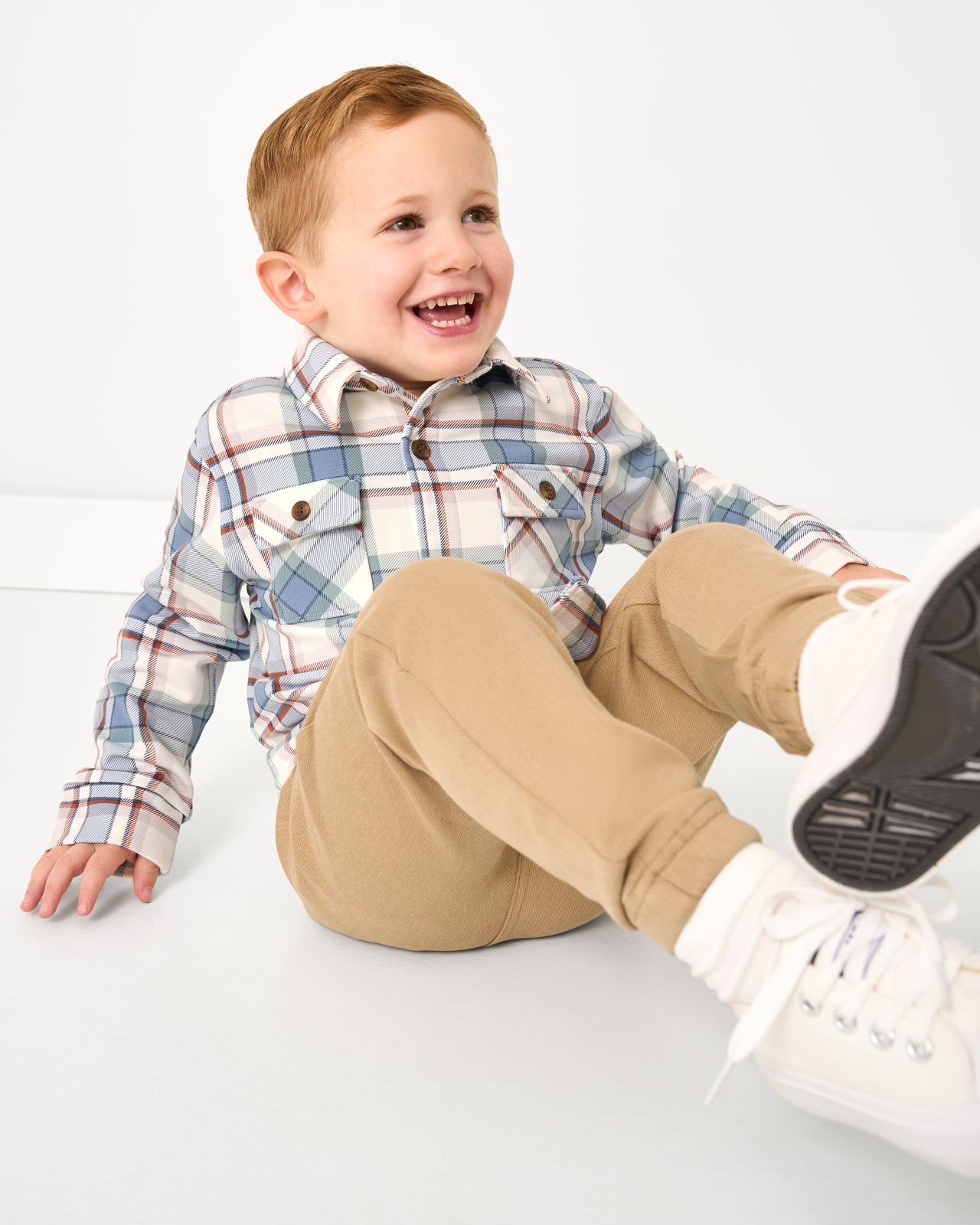 Sitting boy wearing the Blue Ridge Plaid Shacket