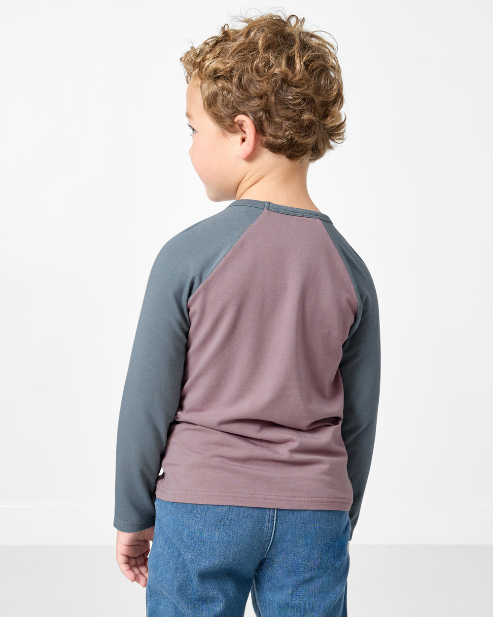 Back view of boy wearing the Bolt Raglan Tee