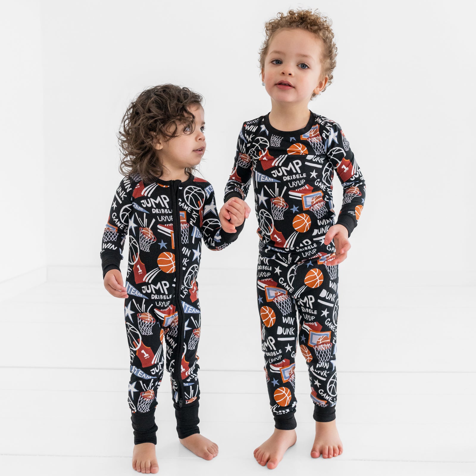 Two children wearing matching Black Slam Dunk bamboo pajamas