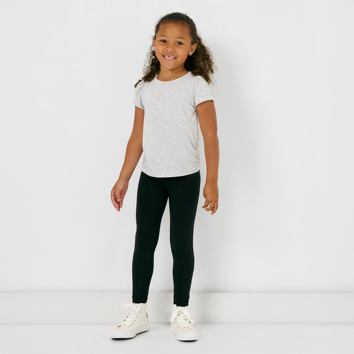 Standing child wearing the Black Legging with a gray puff sleeve tee