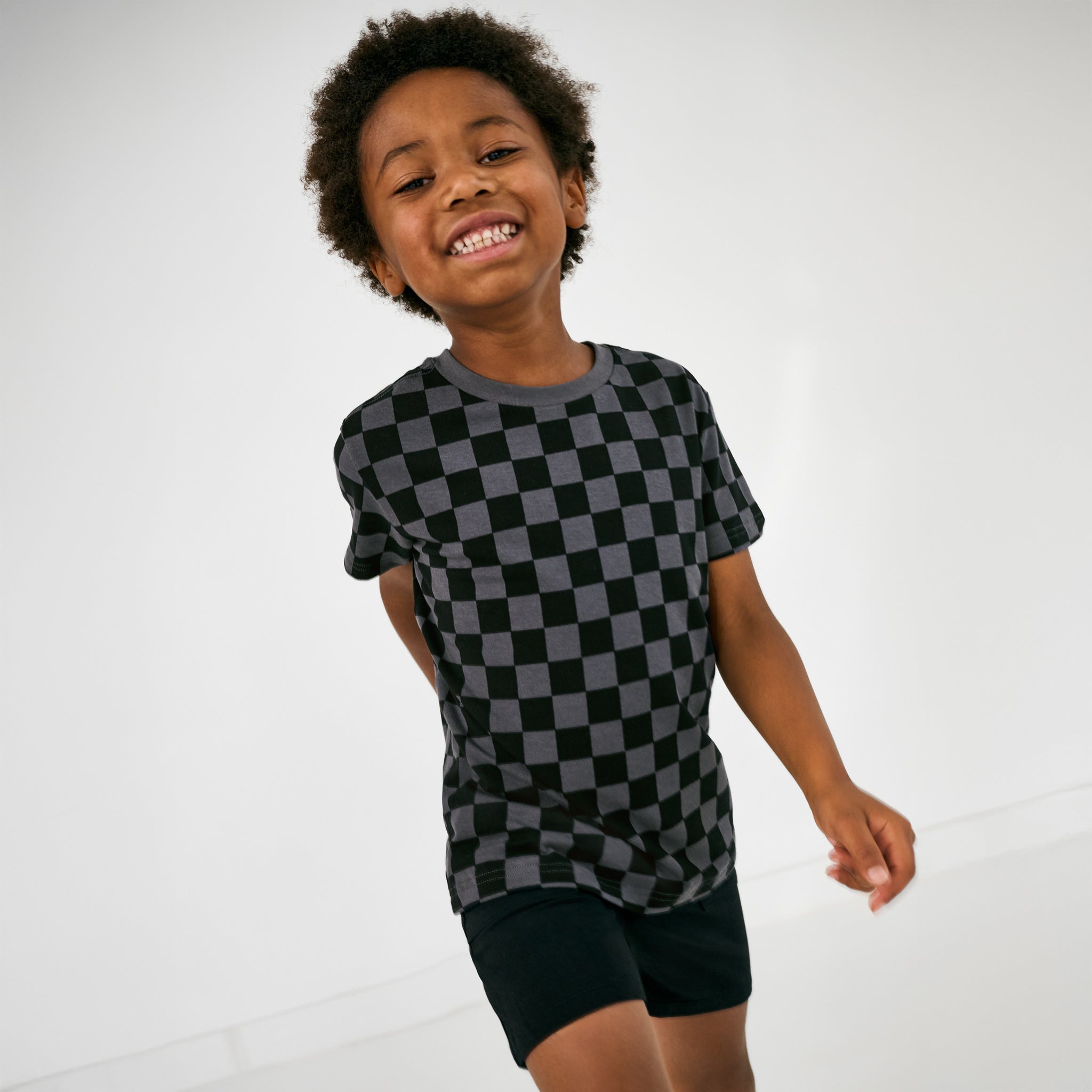 Child in motion wearing the Black Shorts with a monochrome checks tee