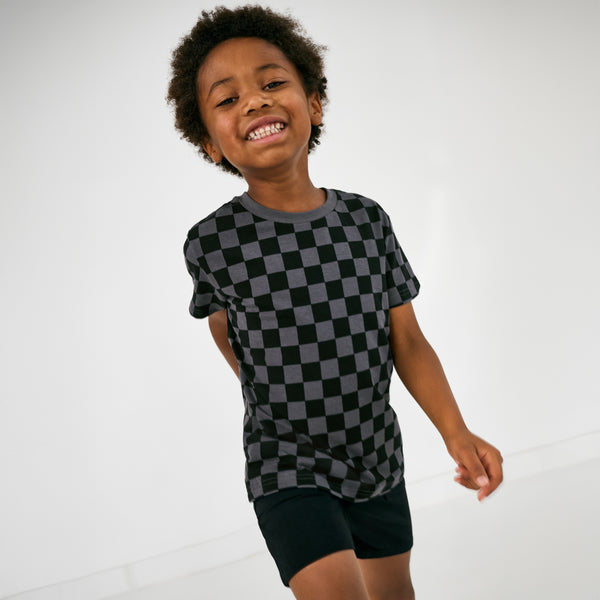 Child in motion wearing the Black Shorts with a monochrome checks tee
