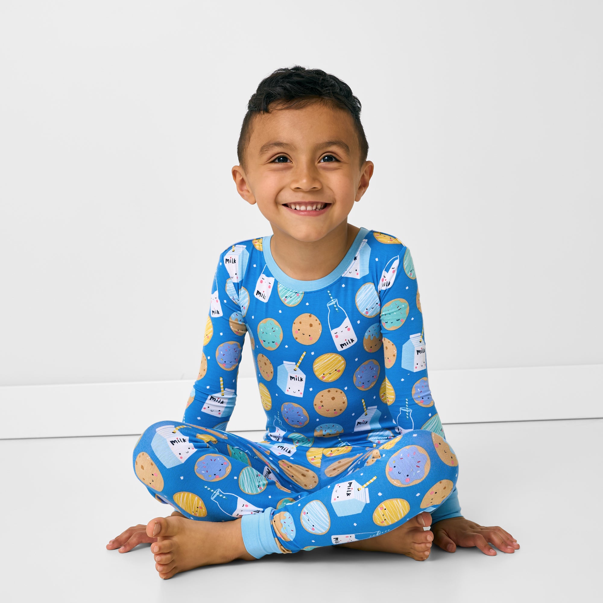Sitting child wearing the Blue Cookies & Milk Two-Piece Pajama Set