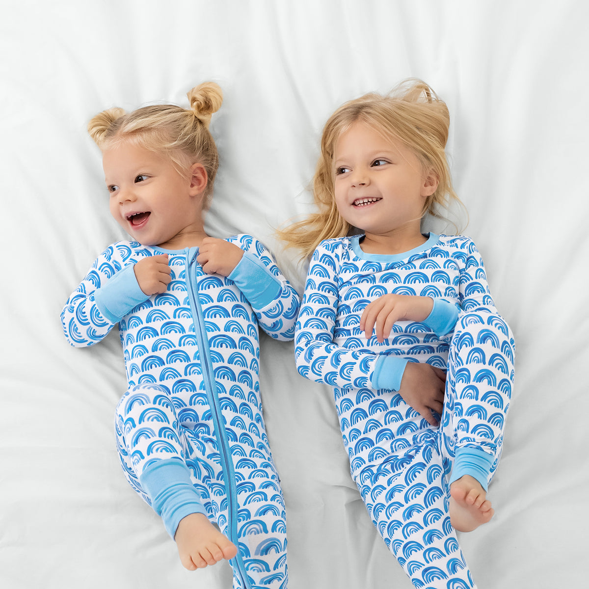 Aerial view of two children wearing matching Blue Rainbows pajamas
