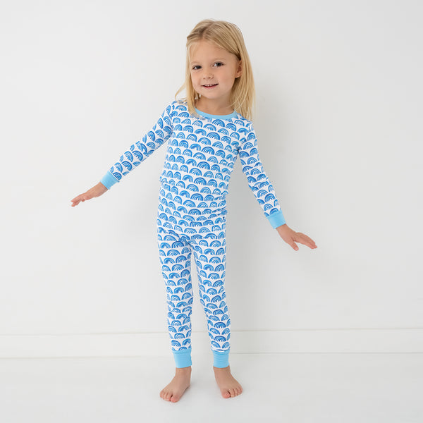 Standing child wearing the Blue Rainbows Two-Piece Pajama Set