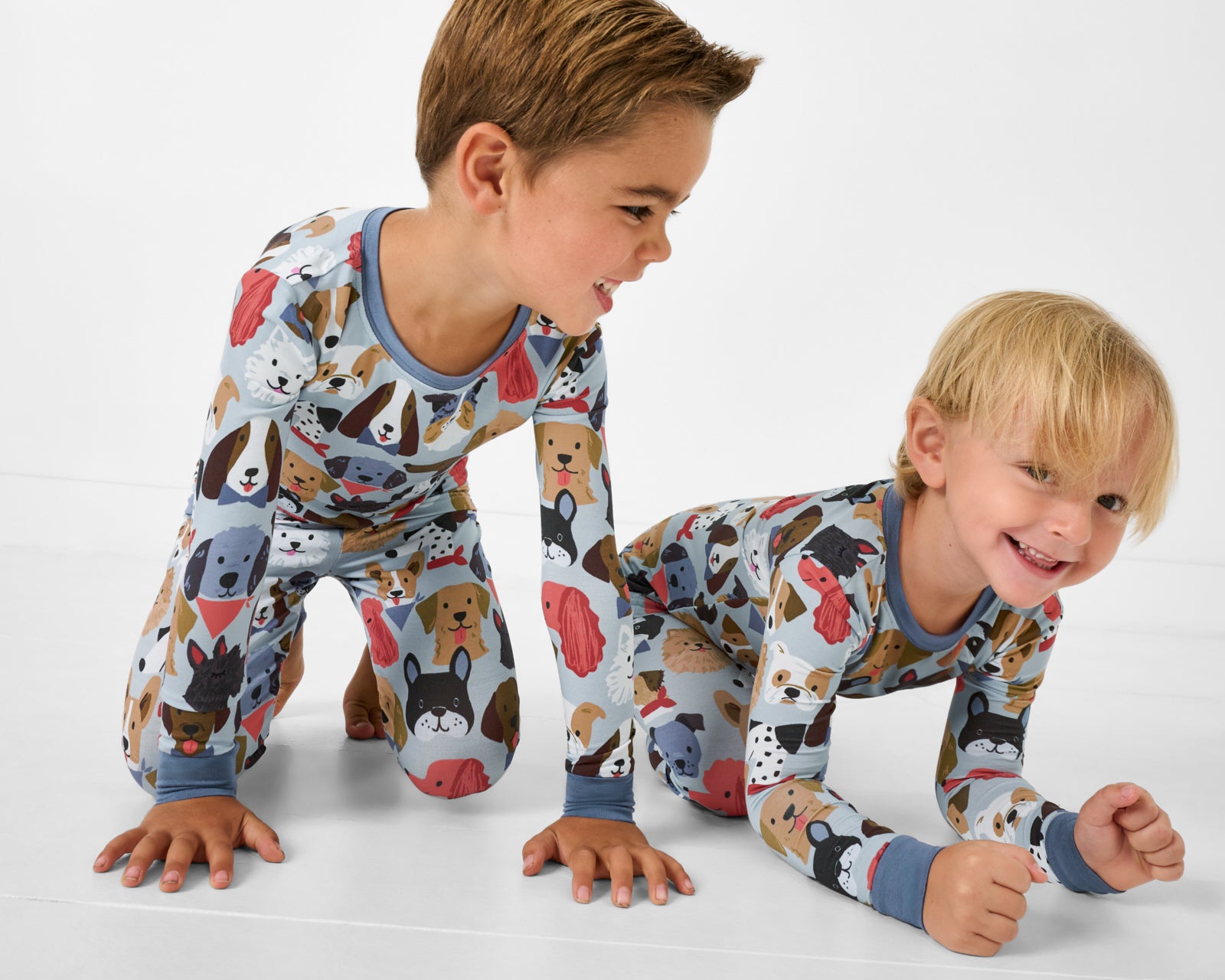 Two boys wearing matching Gray Puppy Parade Two-Piece Pajama Sets