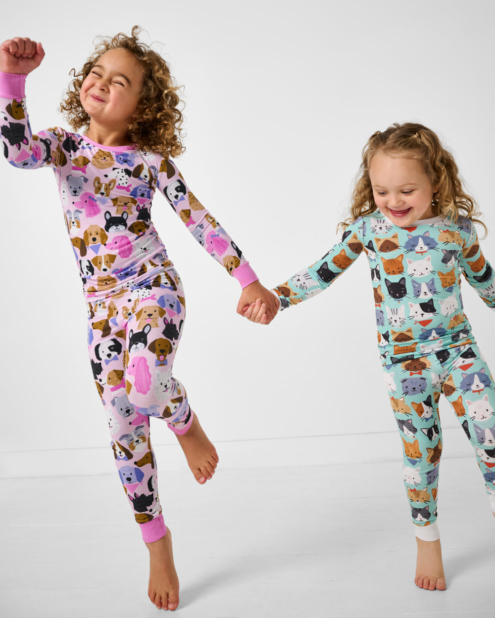 Two girls wearing dog and cat themed pajamas