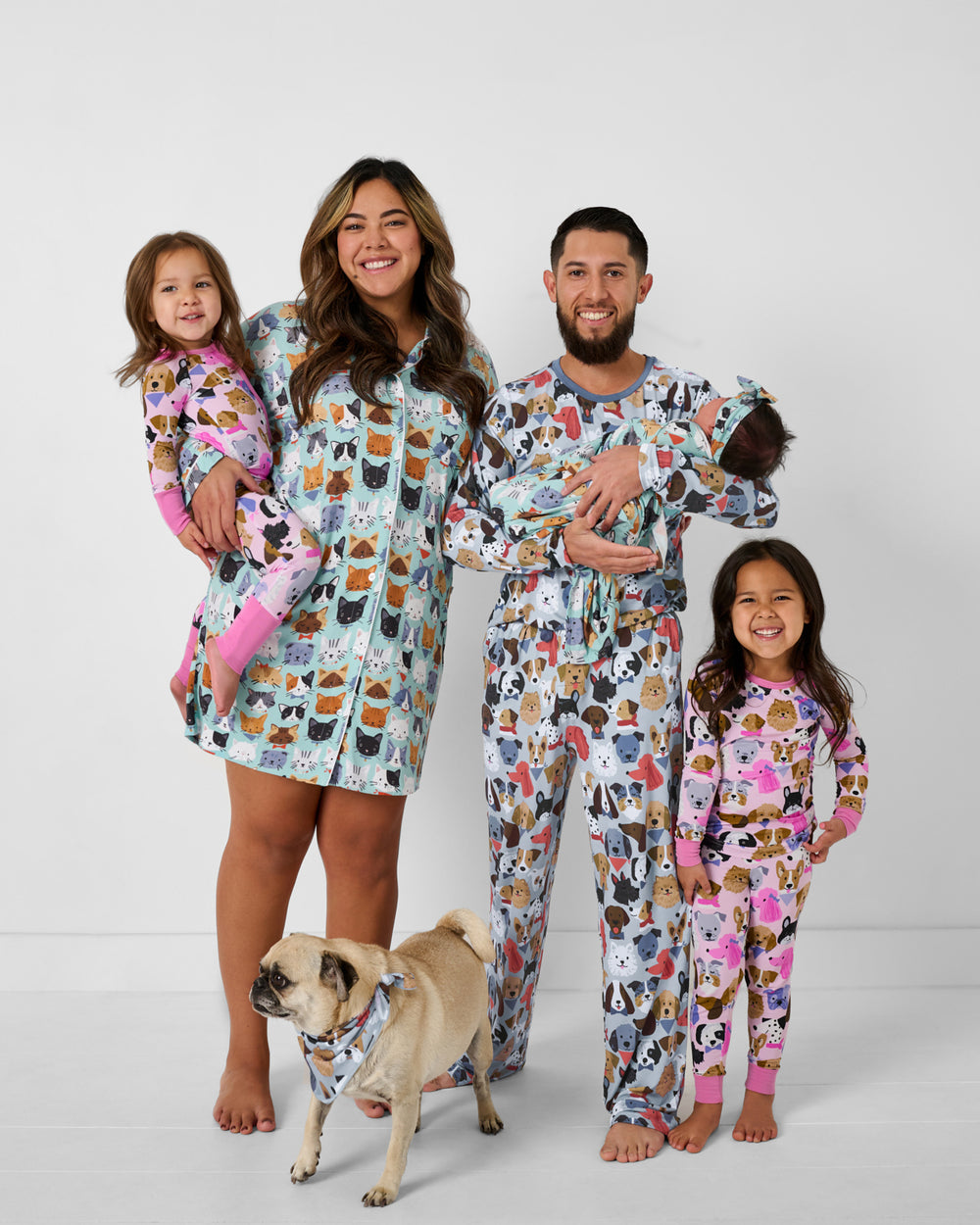 Family of five and dog wearing matching Purrfect Pals and Puppy Parade pajamas