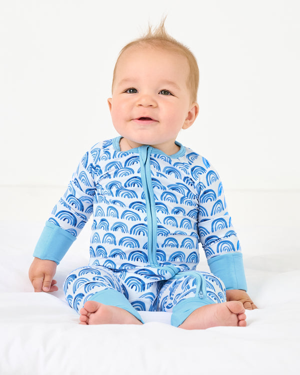 Sitting baby wearing the Blue Rainbows Zippy