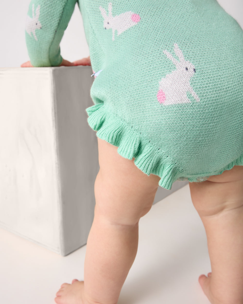 Close up of the ruffle details on the Blush Bunnies Sweater Bubble Romper
