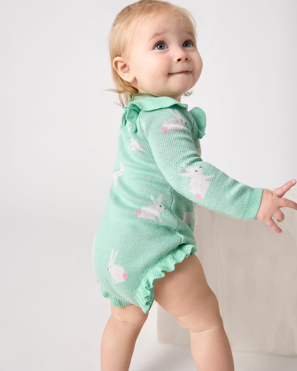 Standing baby wearing the Blush Bunnies Sweater Bubble Romper