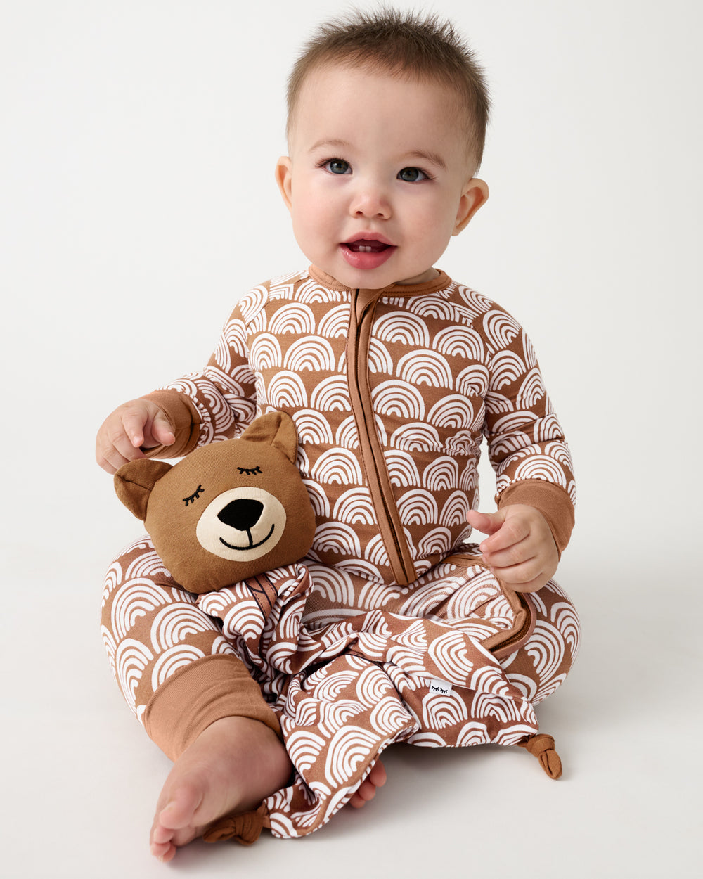 Baby sitting with the Bowie the Bear Sleepyhead Lovey on his lap