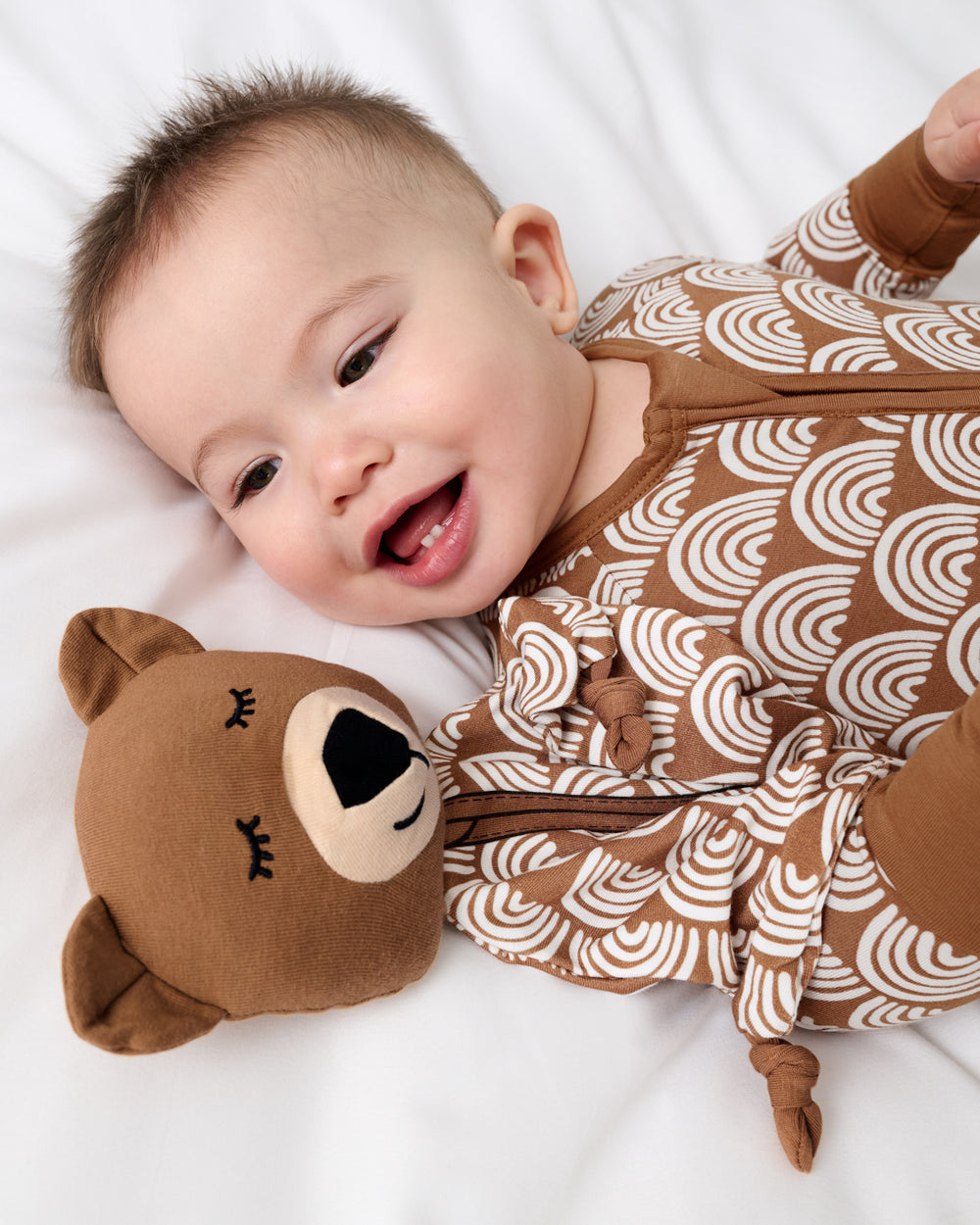Close up of baby laying with the Bowie the Bear Sleepyhead Lovey