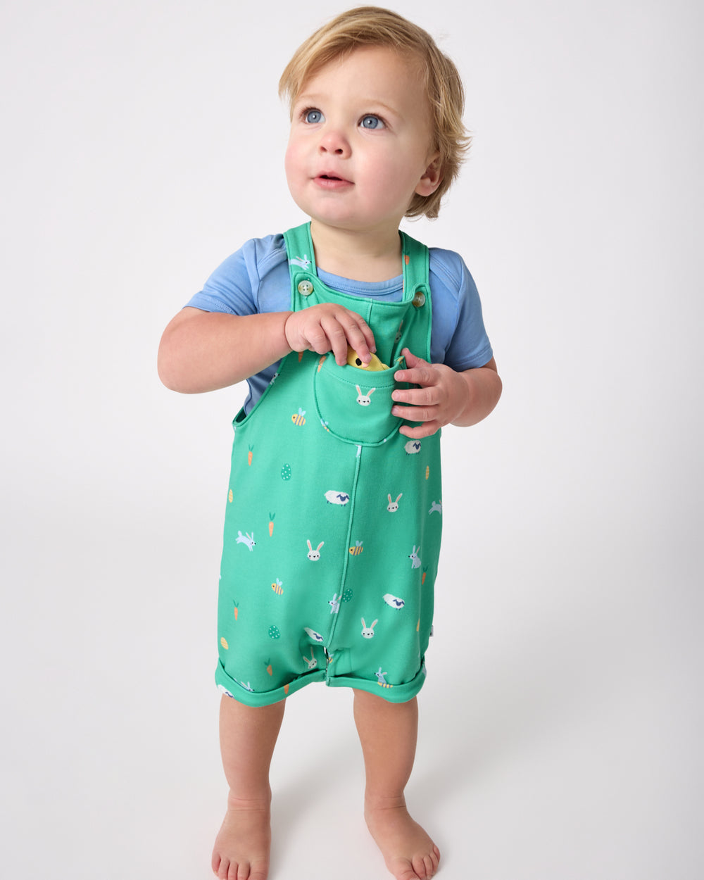 Standing toddler wearing the Bunny Burrow Shorty Overall Set